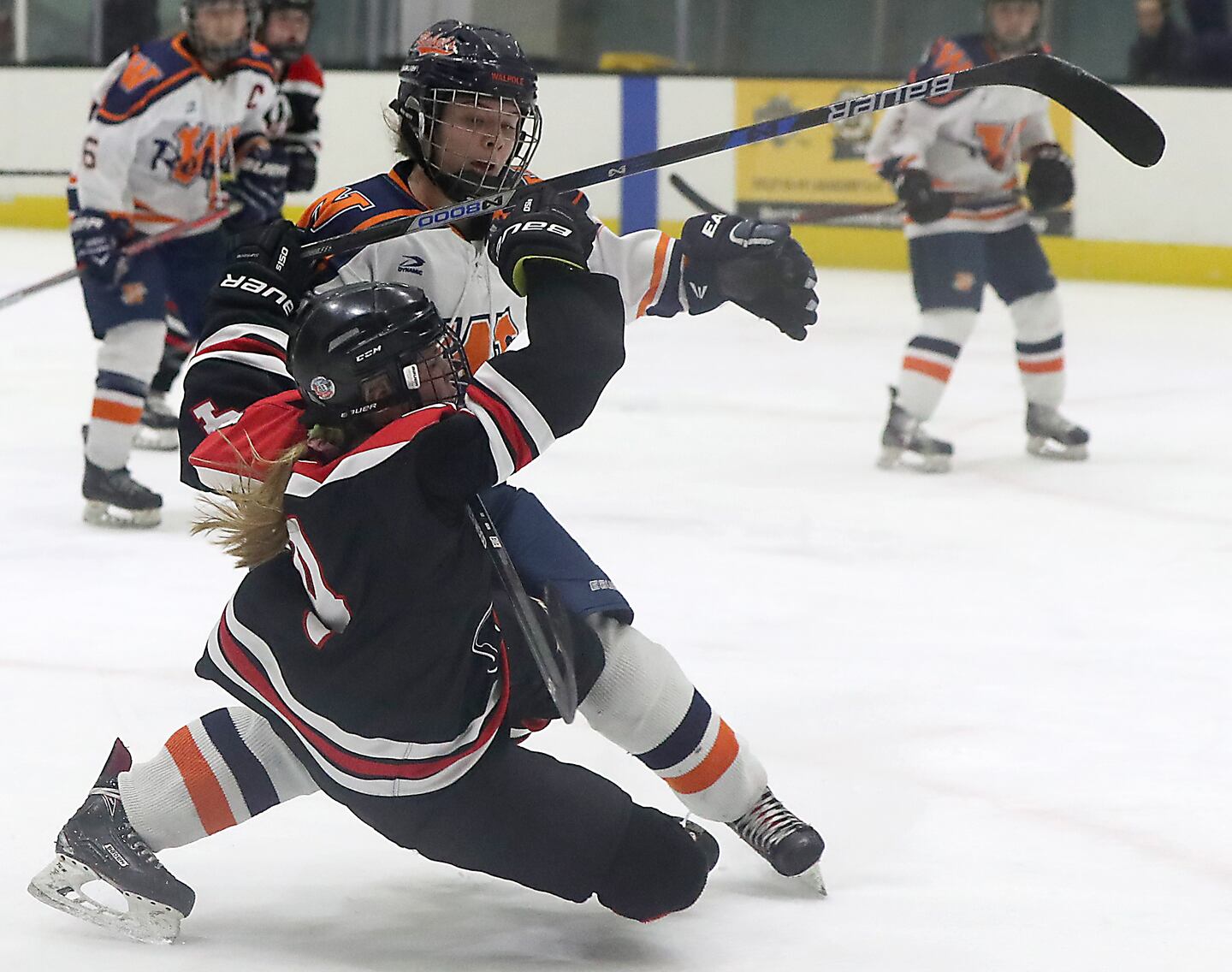 Walpole’s Madison Ryan dumps Wellesley’s Danielle Cimino while going for the puck during the second period.