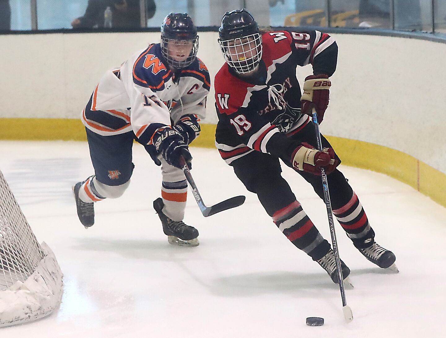 Wellesley’s Erin Fleming (19) escapes pressure from Walpole’s Meghan Hamilton in the first period at Warrior Ice Arena.
